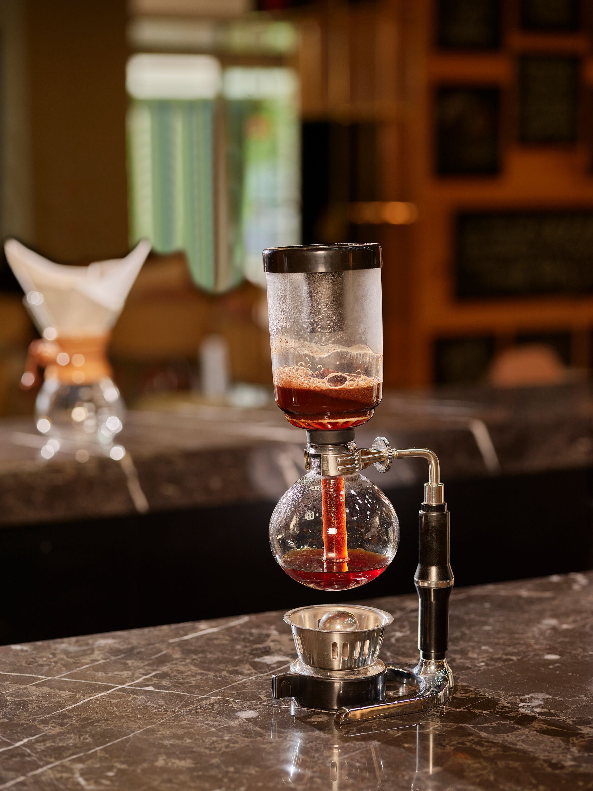 A bar setup with a cocktail shaker and a bottle of liquor.