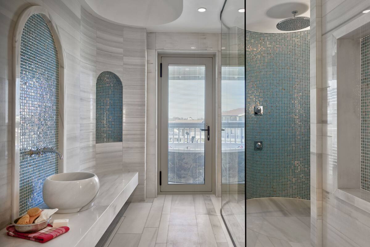 A modern bathroom with a freestanding bathtub, a glass-enclosed shower, and a large mirror.
