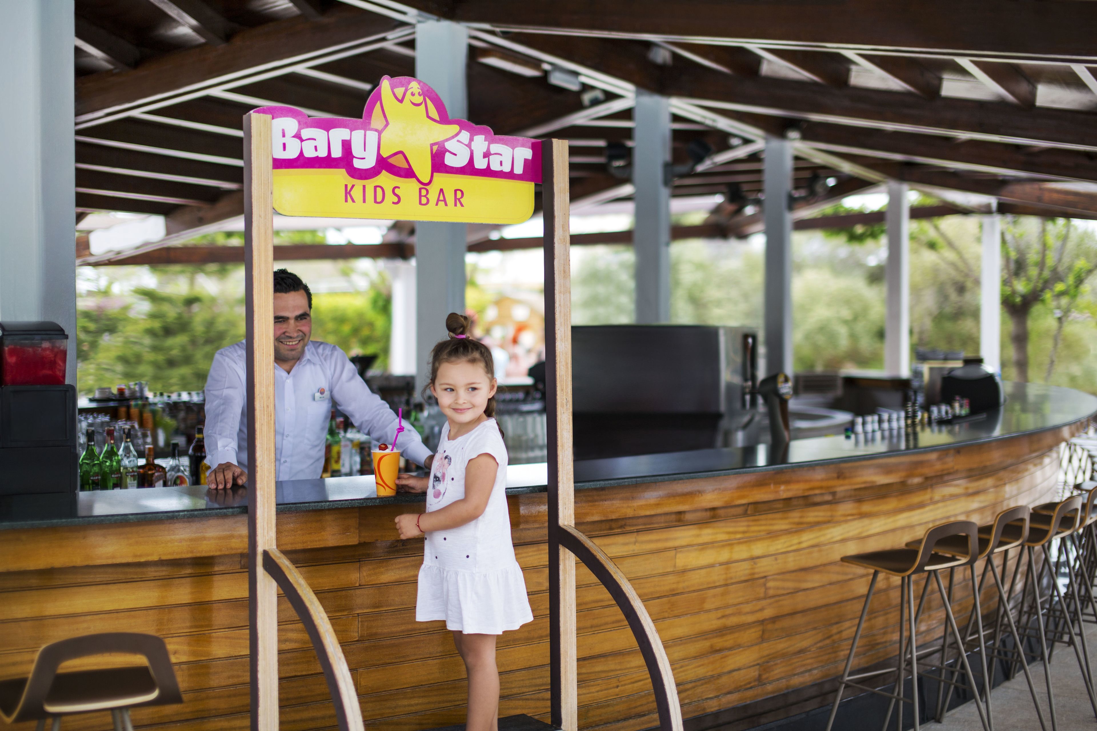 A bar named 'Baby Star Kids Bar' with a wooden counter and stools.