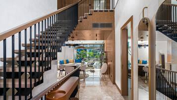 Un intérieur moderne comprenant un escalier, un coin repas et une cuisine.
