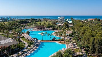 Een binnenzwembad, 3 buitenzwembaden en parasols bij het zwembad