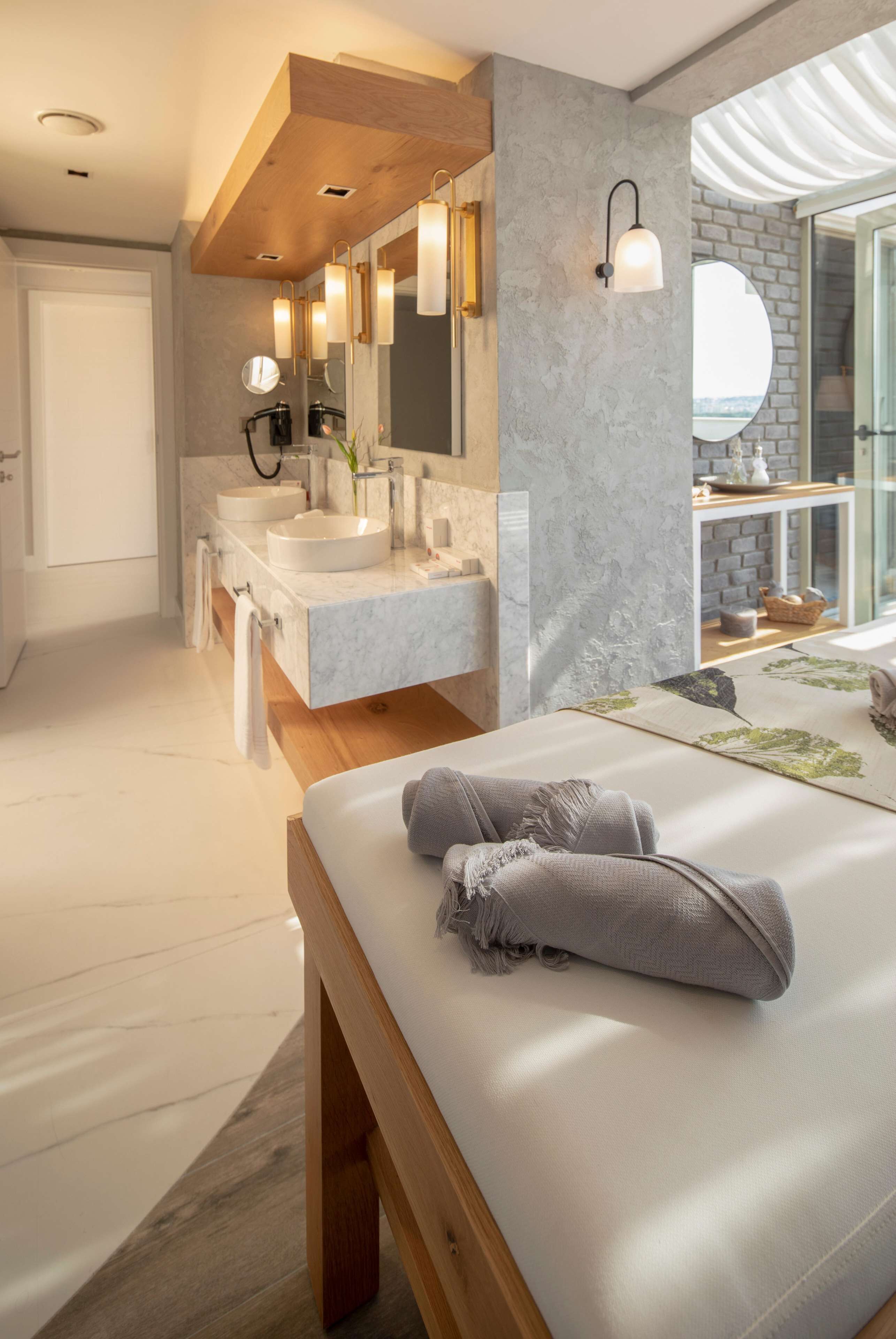 Un baño moderno con dos lavamanos, un espejo grande y techo de madera.