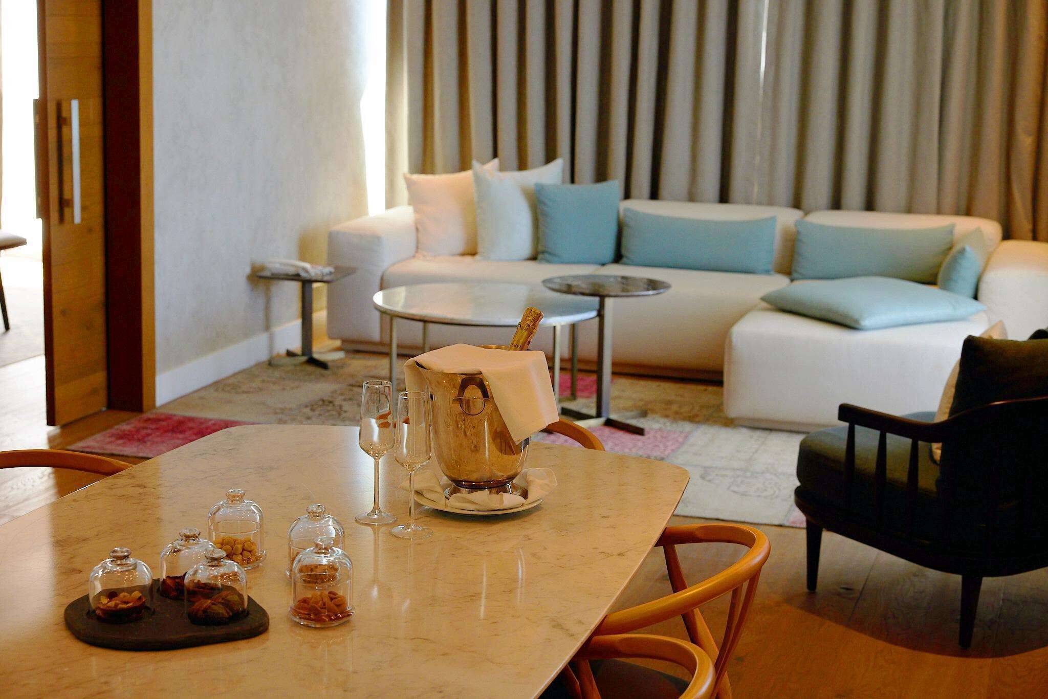 A modern living room with a marble table, a sofa, and a coffee table.