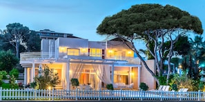 A multi-story building with a balcony, outdoor seating, and a white picket fence. - Papillon Ayscha (Serik)