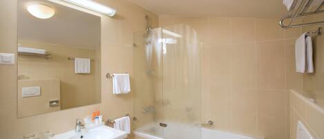 A bathroom with a sink, mirror, and a glass-enclosed shower.