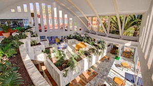 Ein großzügiger Innenhof mit hoher Decke, Marmorböden und verschiedenen Sitzbereichen.