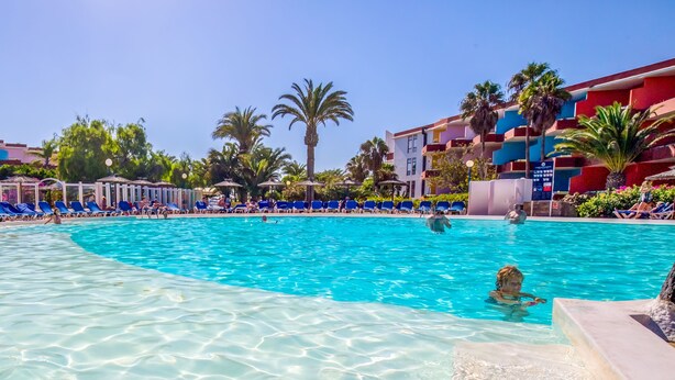 Ein Poolbereich mit blauen Liegestühlen und einem klaren, blauen Pool.