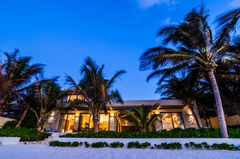 A resort with thatched-roof buildings, a swimming pool, and a beach view. at Ana y Jose Tulum Hotel & Spa