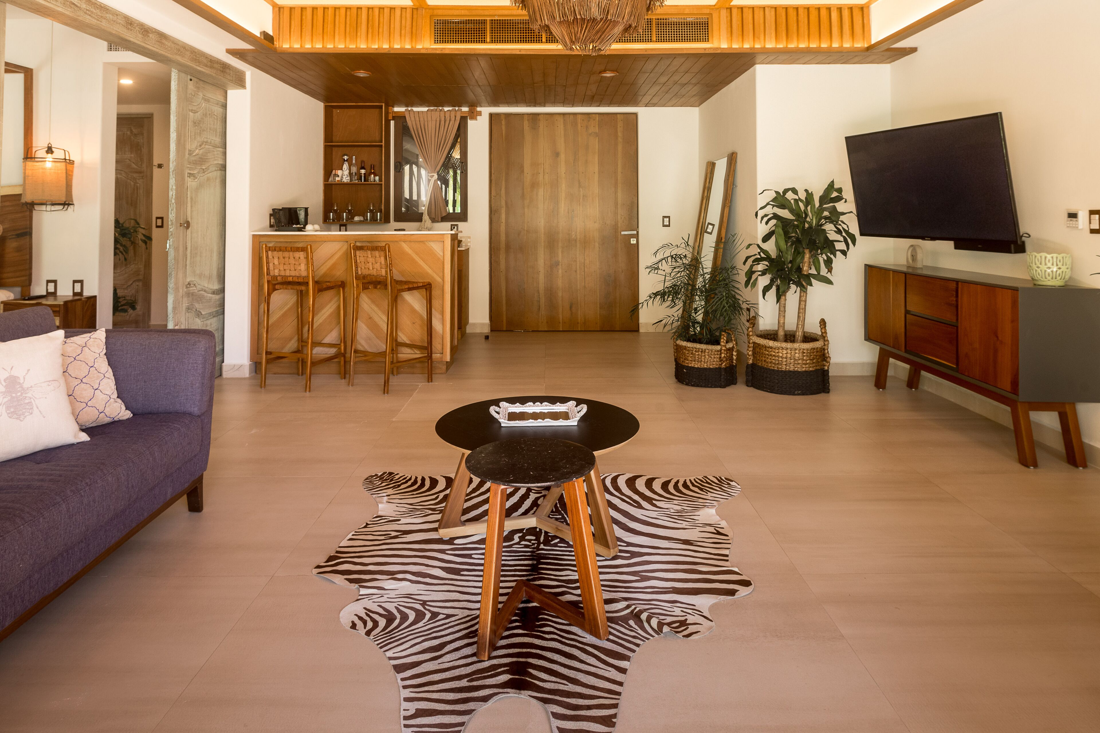 A modern living room with a sofa, a zebra-patterned rug, a coffee table, and a TV.