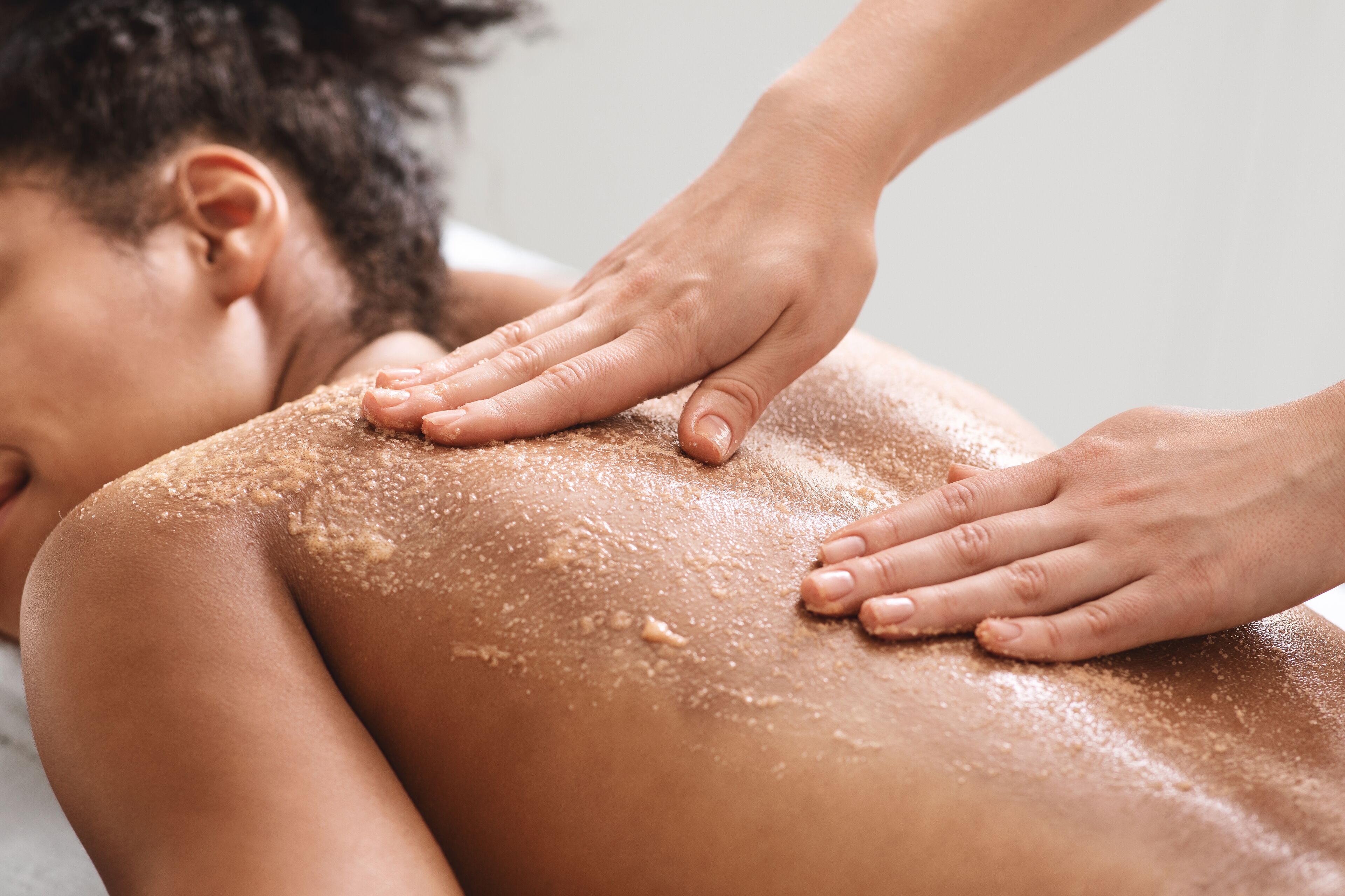 A person receiving a back massage with a focus on the hands and the back.