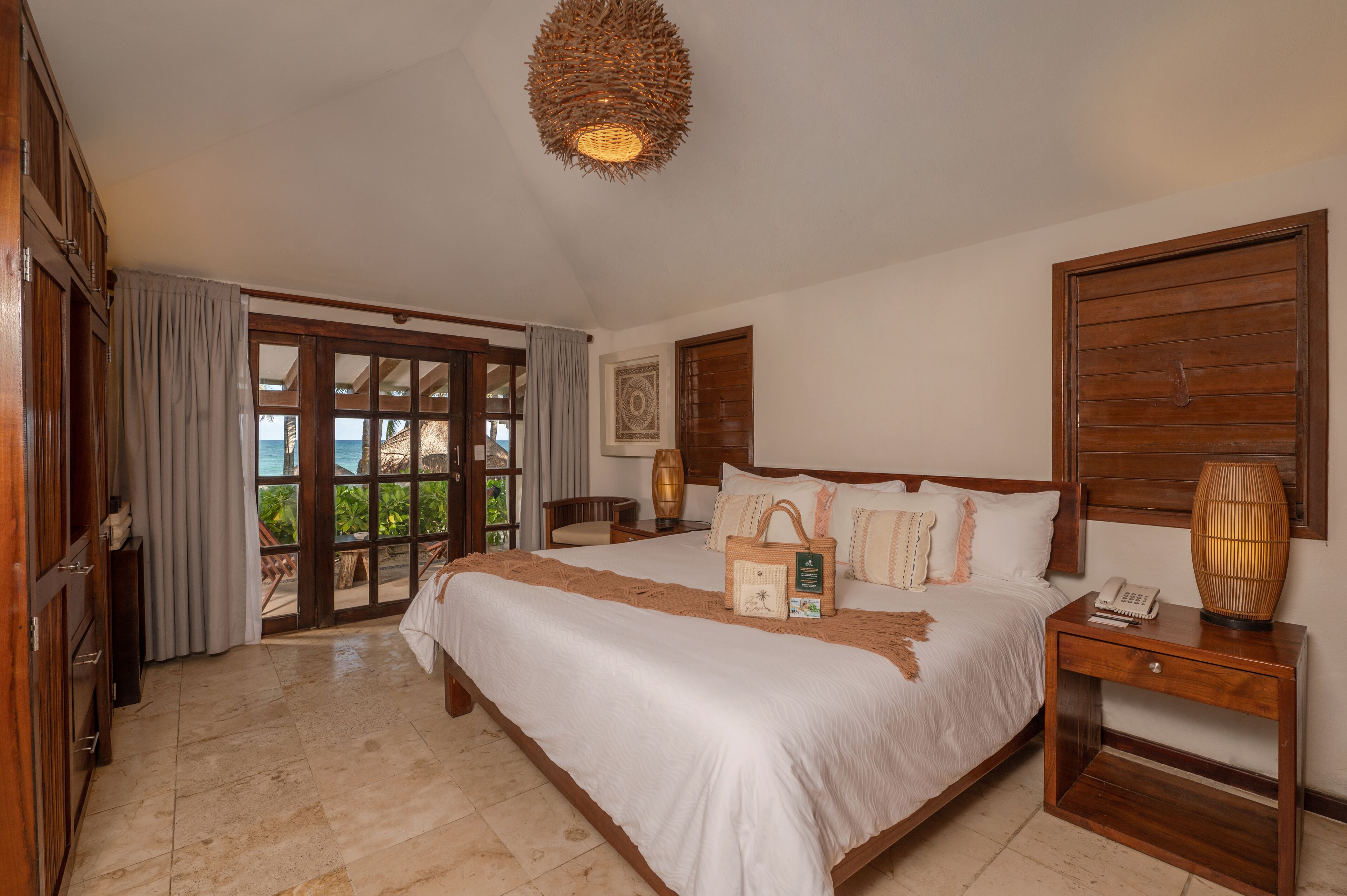 A spacious bedroom with a large bed, wooden headboard, and a nightstand with a lamp.