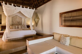 A covered outdoor area with a wooden structure, surrounded by palm trees and tropical plants. at Ana y Jose Tulum Hotel & Spa