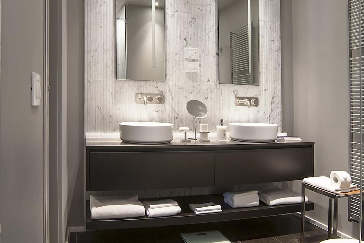 Une salle de bain moderne avec deux lavabos, un miroir et un porte-serviettes.