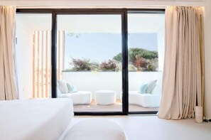 A bedroom with a large sliding glass door leading to a balcony with outdoor seating. - Hotel Byron (Forte dei Marmi)