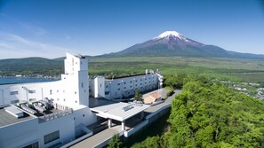 Un edificio moderno con techo plano, una gran estructura blanca con múltiples ventanales, y un edificio más pequeño con techo inclinado.