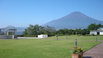 A well-maintained grassy area with a gazebo, a pathway, and a building with a dome structure.