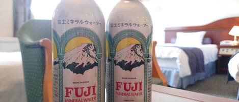 Two bottles of Fuji Mineral Water on a table in a hotel room.