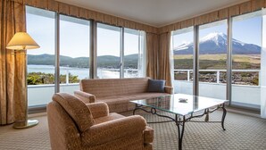 A hotel room with a sofa and a glass table, large windows with a mountain view. - Hotel Mt. Fuji (Yamanakako)