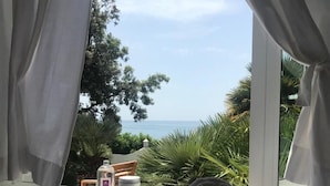 A hotel room with a view of the sea, a bed with a towel, and a small table with toiletries. - Hotel Punta Rossa (San Felice Circeo)