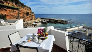 A dining table with a fruit bowl and tableware on a balcony overlooking the sea. - Hotel Punta Rossa (San Felice Circeo)