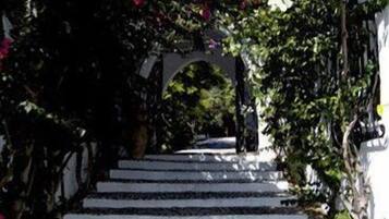 Un escalier aux marches blanches et un chemin de pierre menant à un bâtiment blanc.