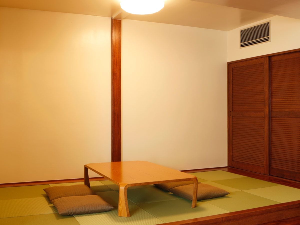 A room with tatami flooring, a low wooden table, and a traditional sliding door.