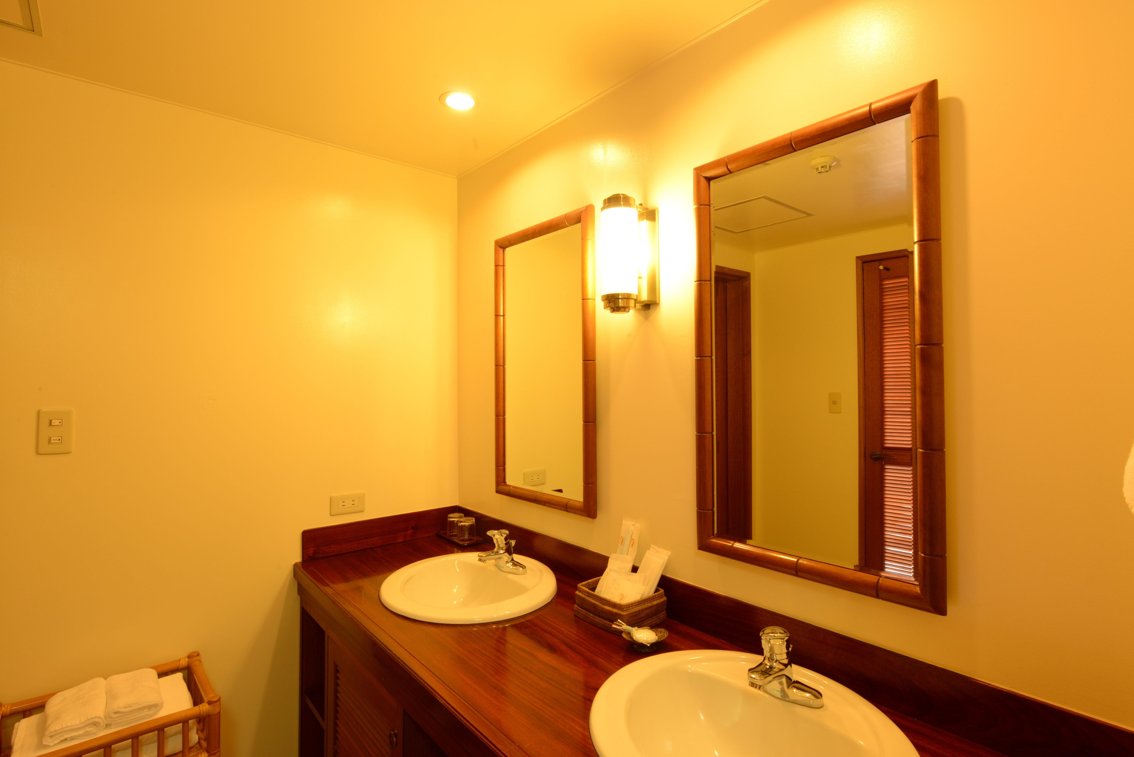 A bathroom with two sinks, a mirror, and a wooden vanity.