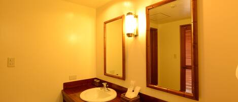 A bathroom with two sinks, a mirror, and a wooden vanity.