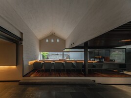 Un interior moderno con área de cocina, comedor y vistas al exterior.