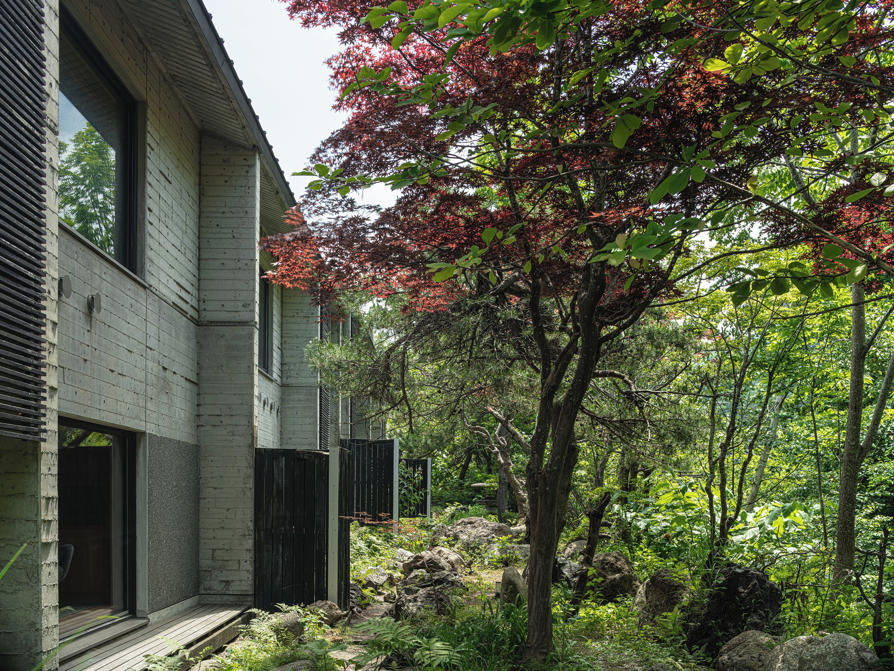 A modern building with large windows and a wooden deck.