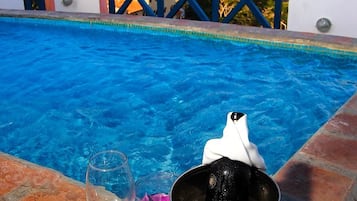 A poolside setting with a clear view of the sea and buildings in the background.