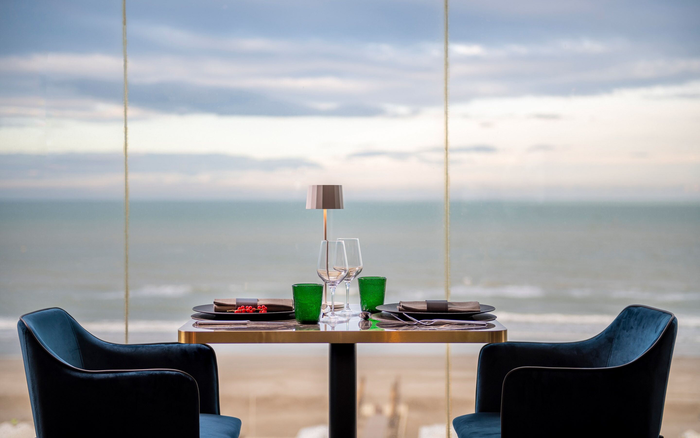 A table set for two with a view of the ocean.