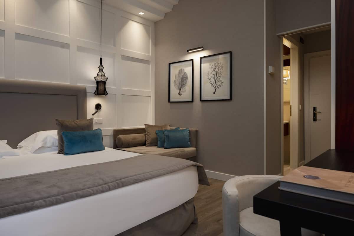 A modern bedroom with a large bed, two bedside tables, and a desk.