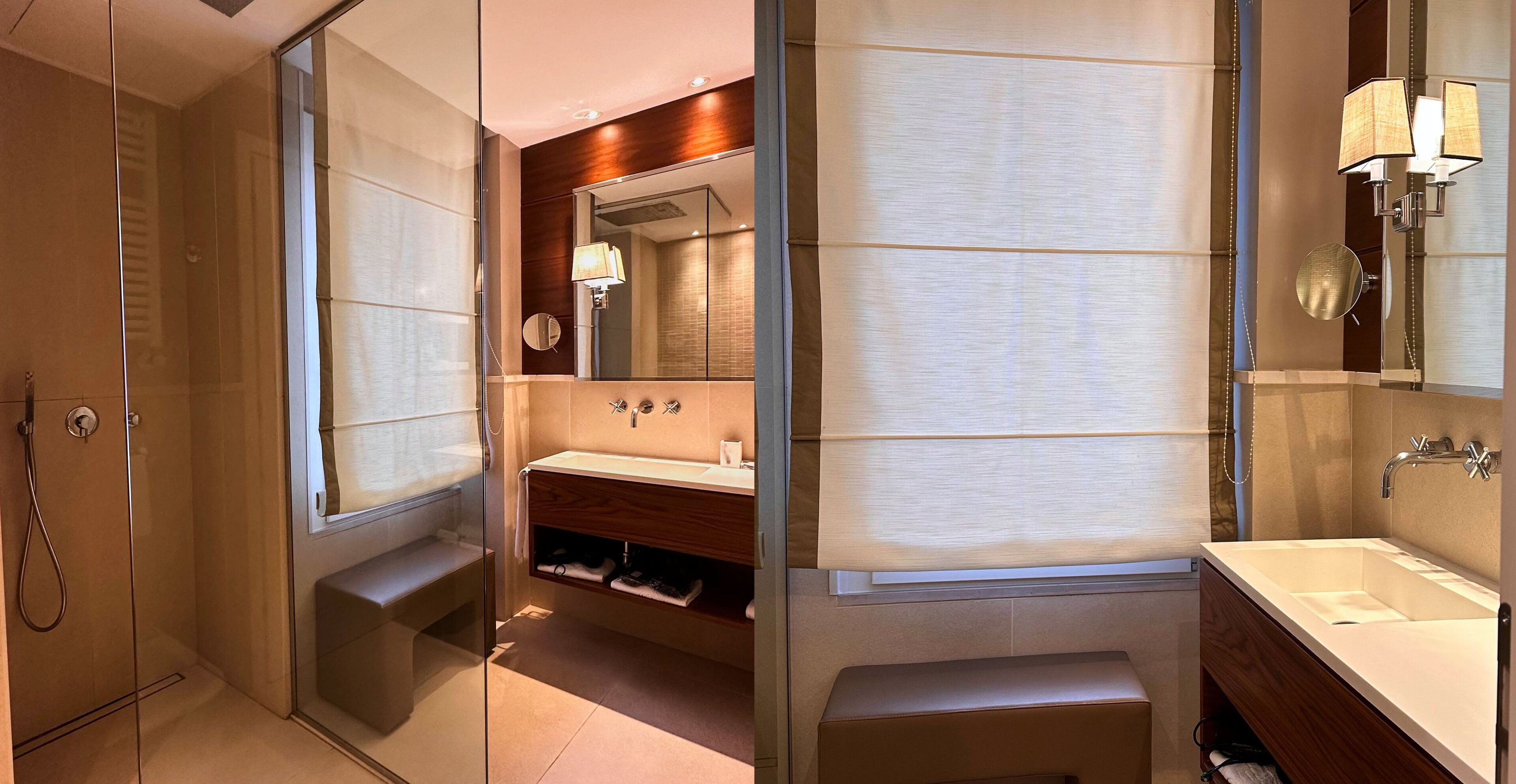 Un baño moderno con ducha de vidrio, tocador con espejo y un lavamanos grande.
