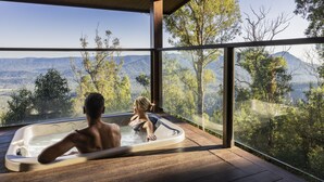 A hot tub with a view of a mountainous landscape.
