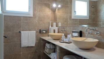 Ein modernes Badezimmer mit zwei großen, beige farbenen Waschbecken, einem Spiegel und einem Handtuchhalter.