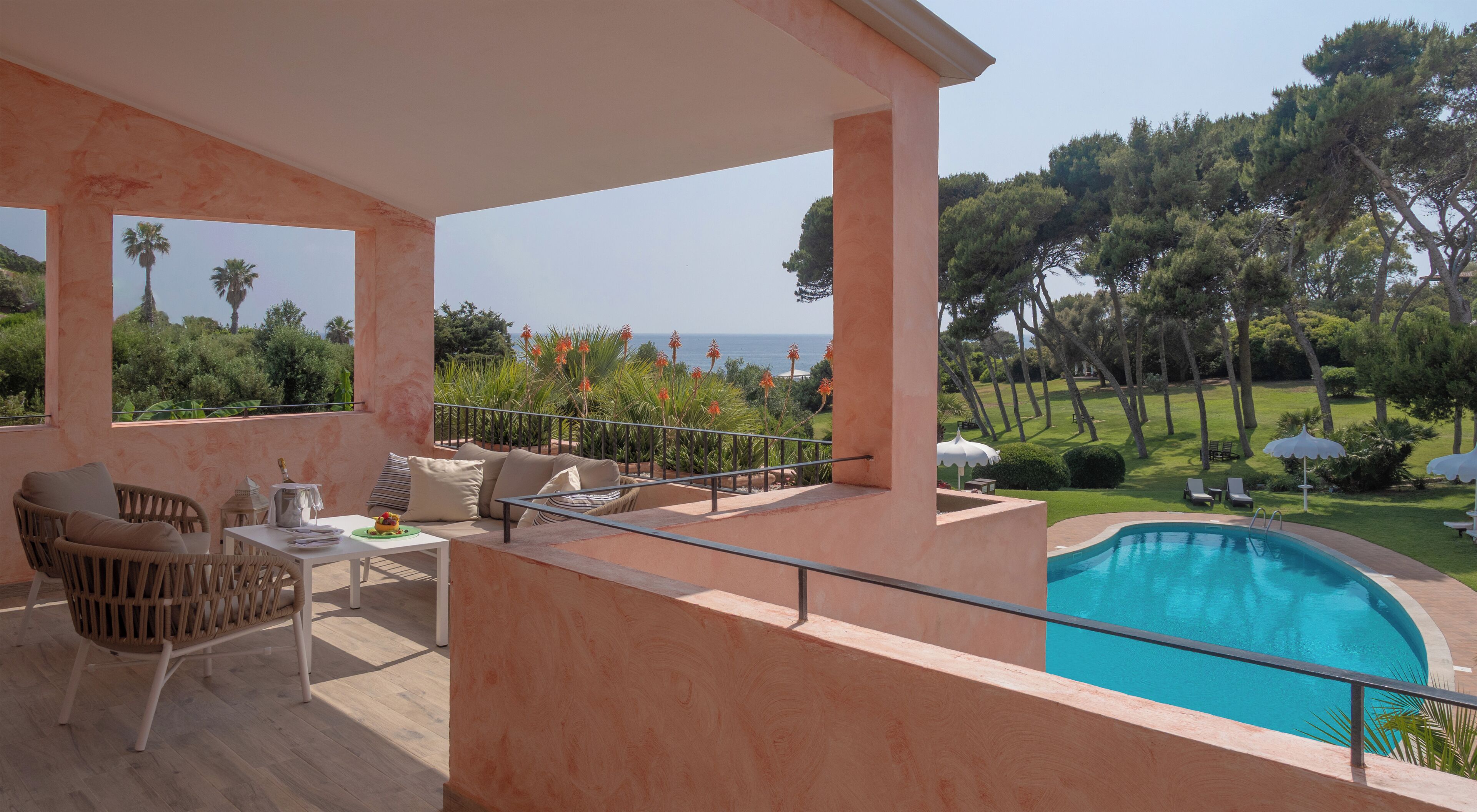 A balcony with a pool, outdoor furniture, and a view of the sea.