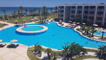 Una piscina techada, 2 piscinas al aire libre, sombrillas
