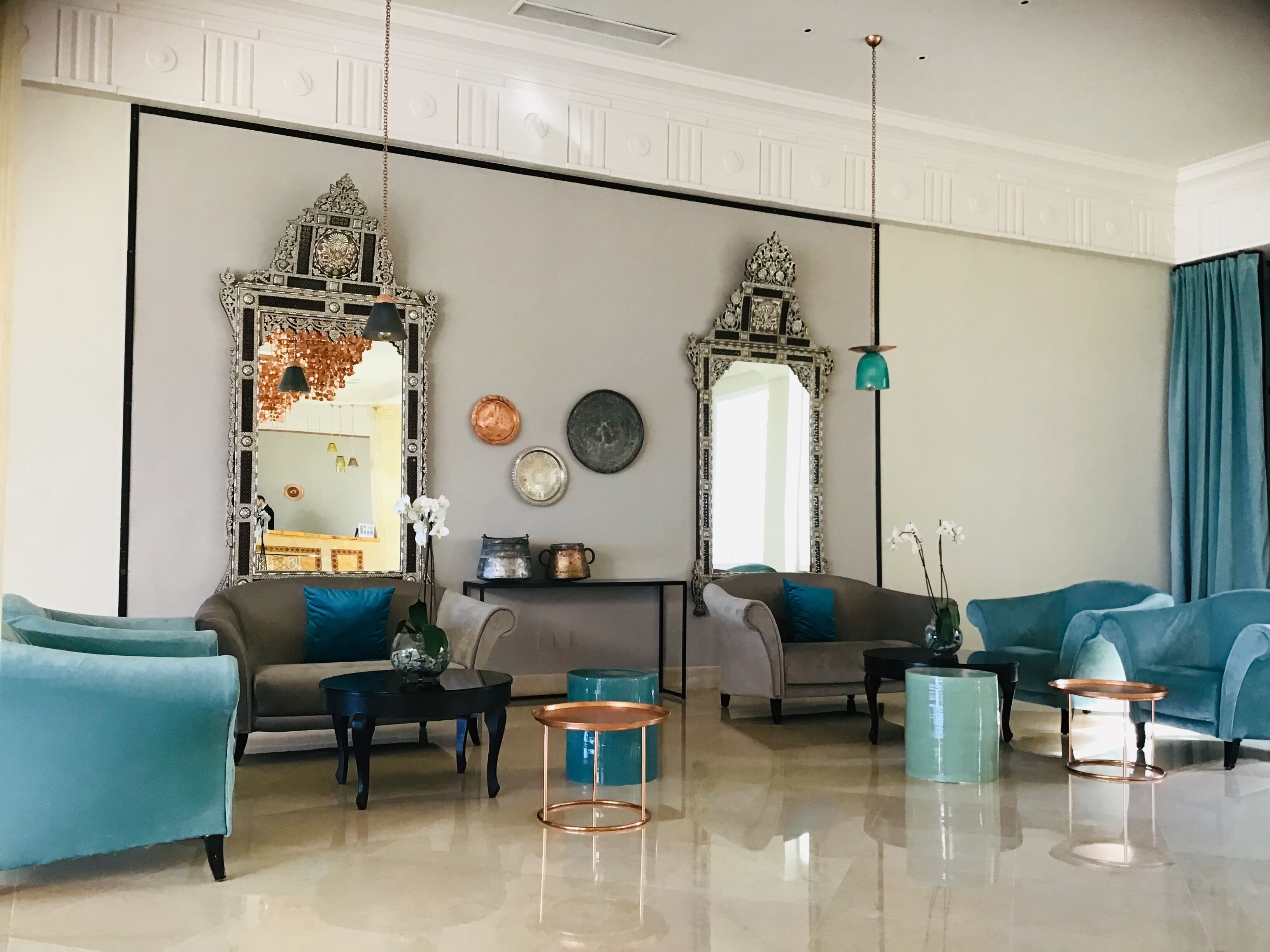 Un salon spacieux avec un grand miroir, deux canapés et une table basse.