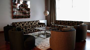 A modern living room with a sectional sofa, a coffee table, and round ottomans.