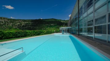 Piscine couverte, piscine extérieure, parasols de plage, chaises longues