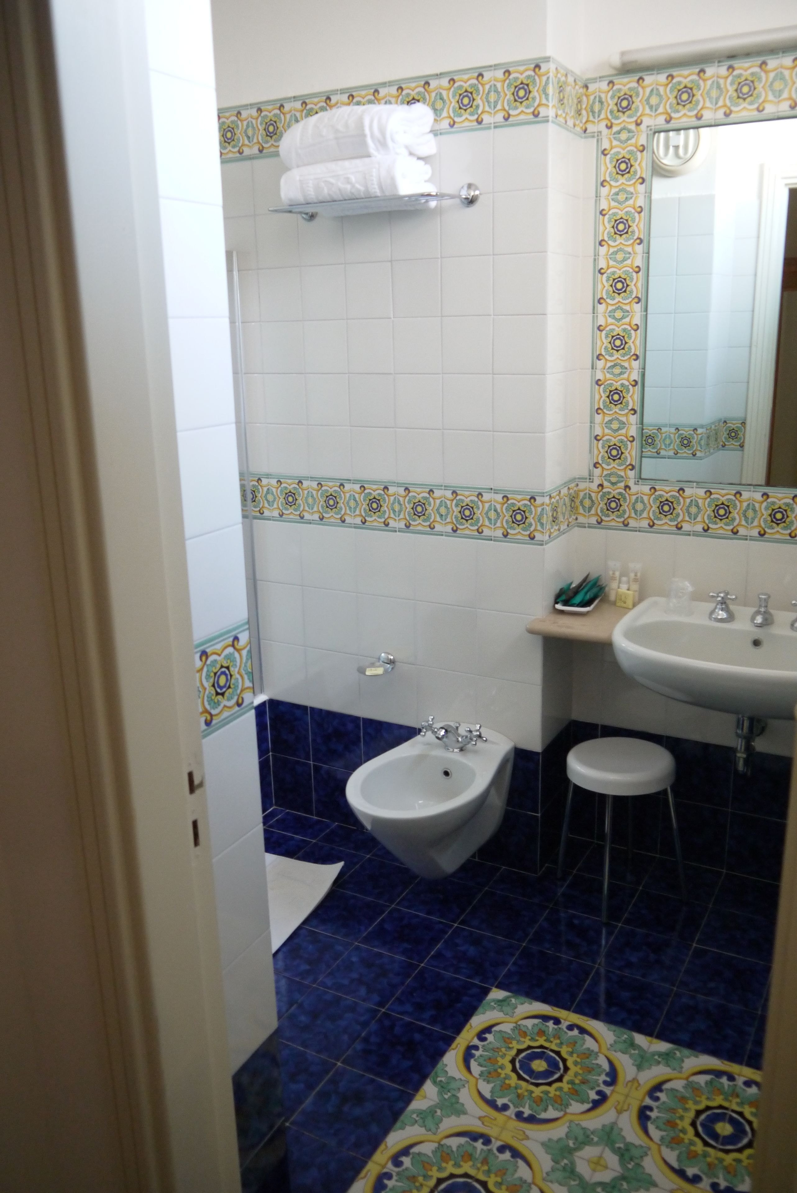 A bathroom with a bidet, a sink, and a mirror.