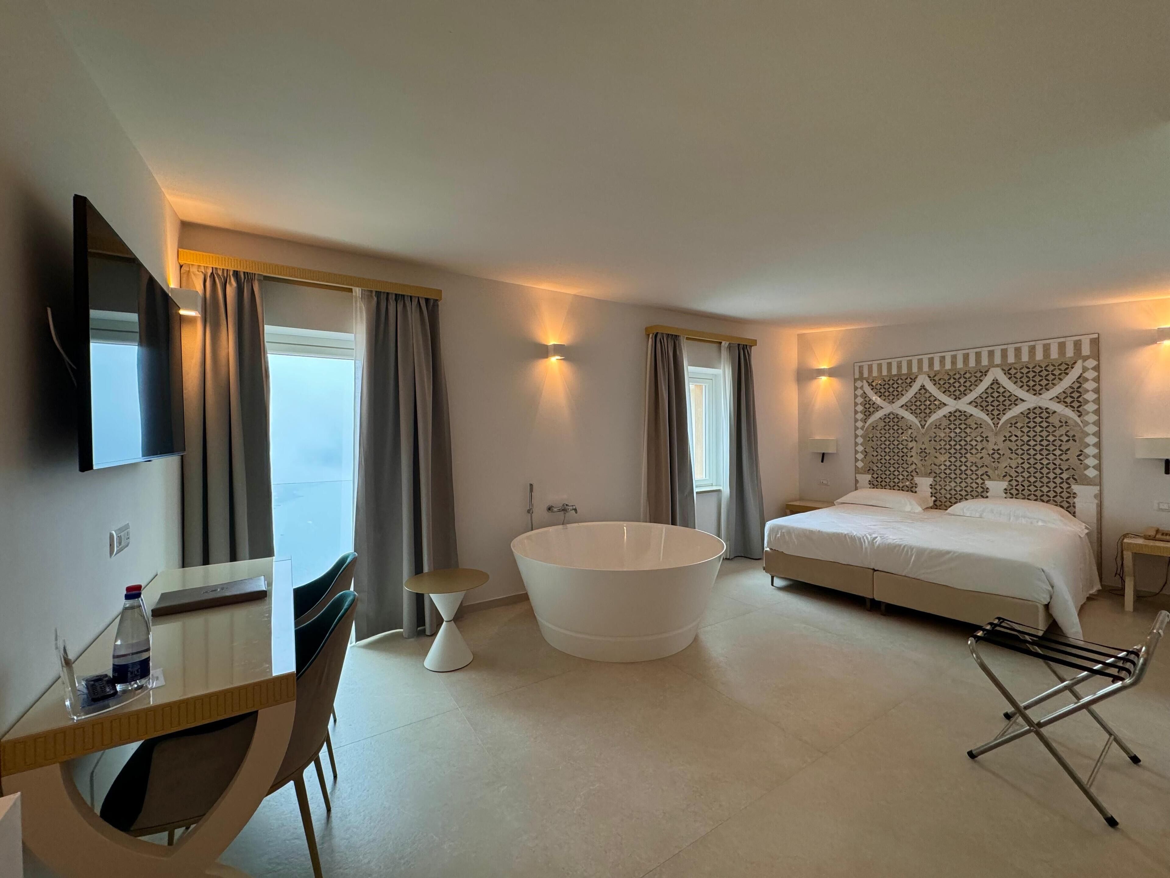 deluxe room, sea view | minibar, in-room safe, desk, blackout curtains