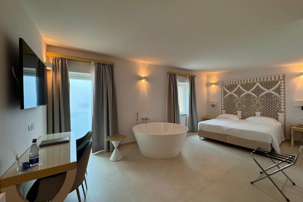 deluxe room, sea view | minibar, in-room safe, desk, blackout curtains