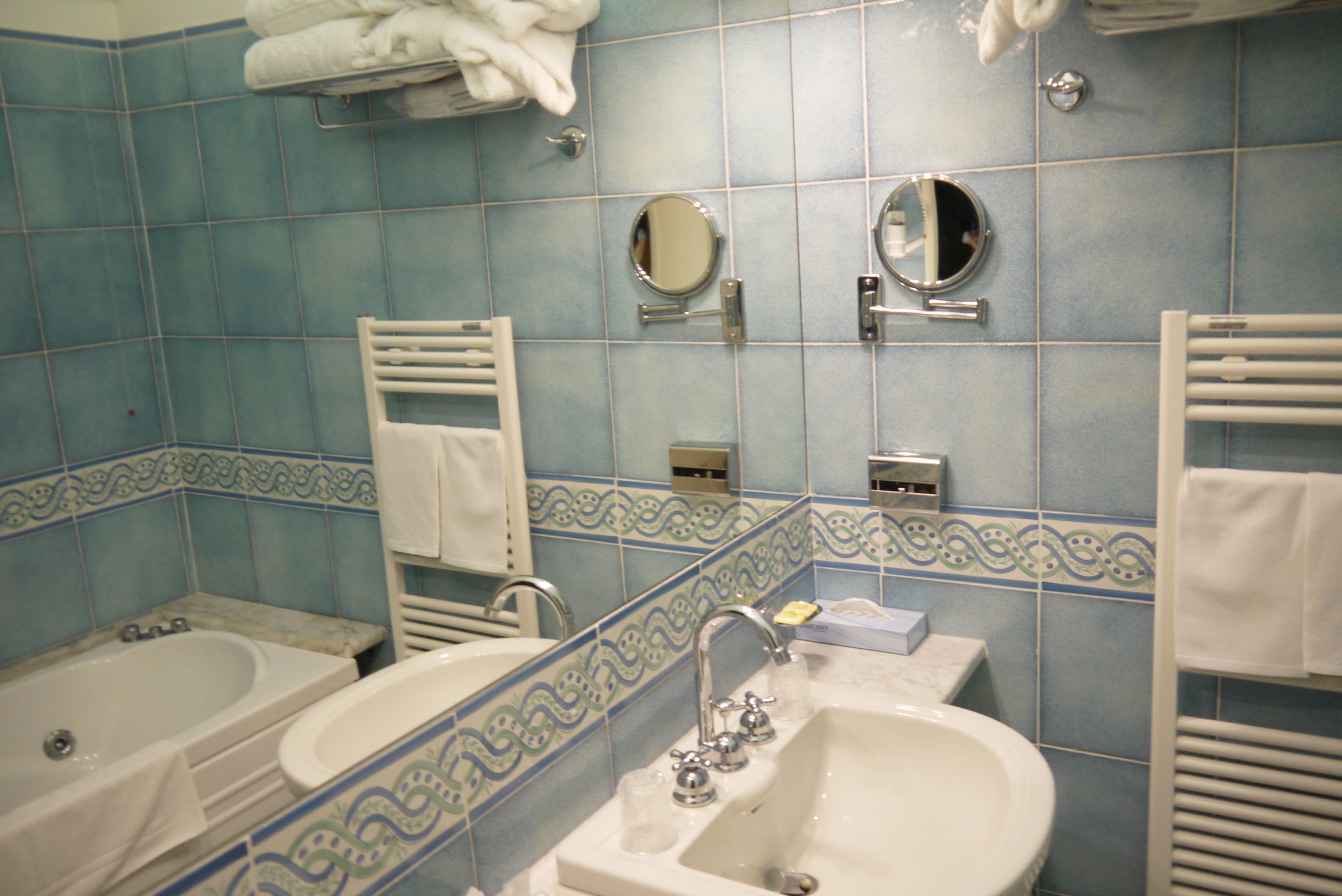 A bathroom with two sinks, a bathtub, and a mirror.