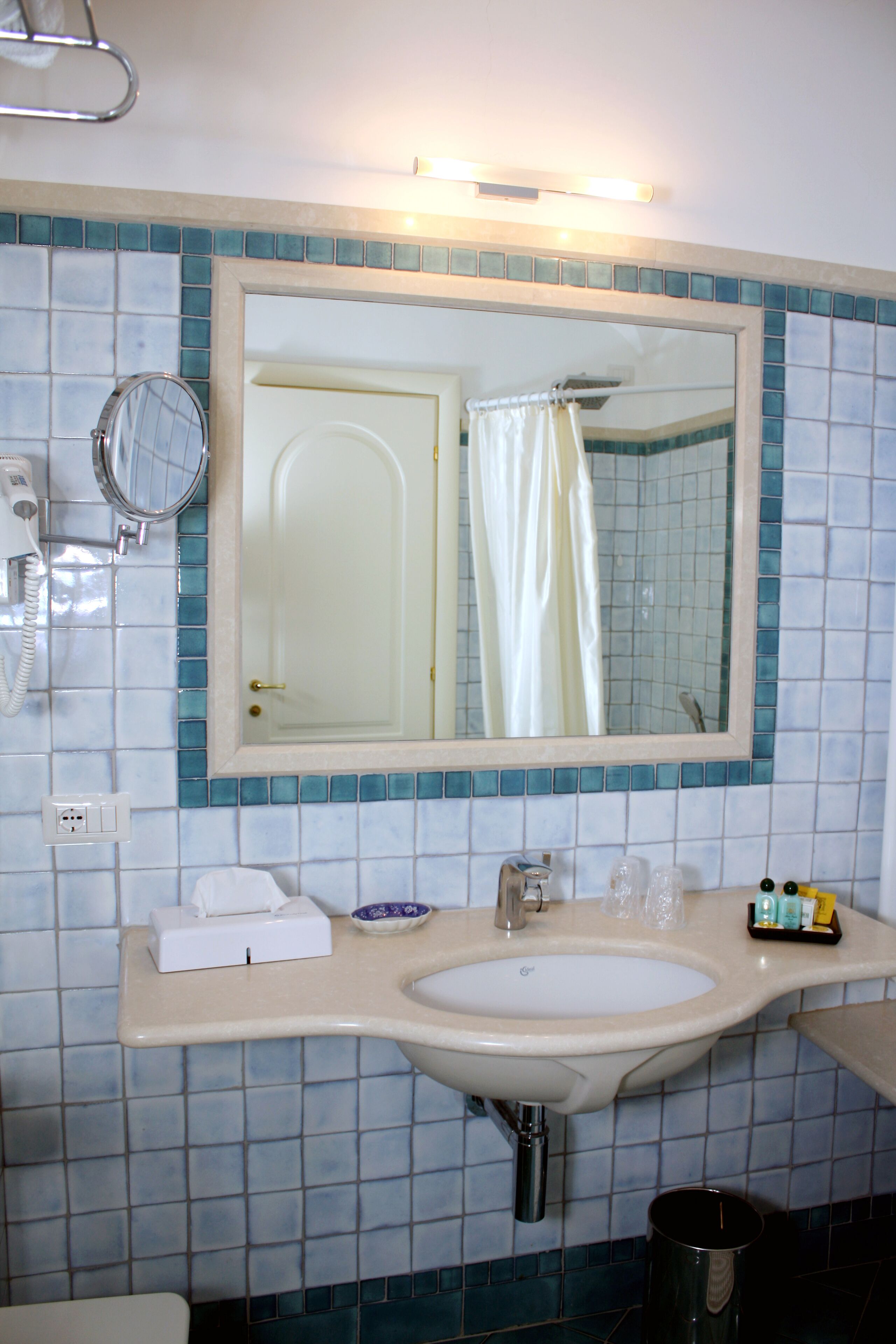 Baño con lavamanos, espejo y cortina de ducha.