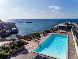 Een buitenzwembad en ligstoelen