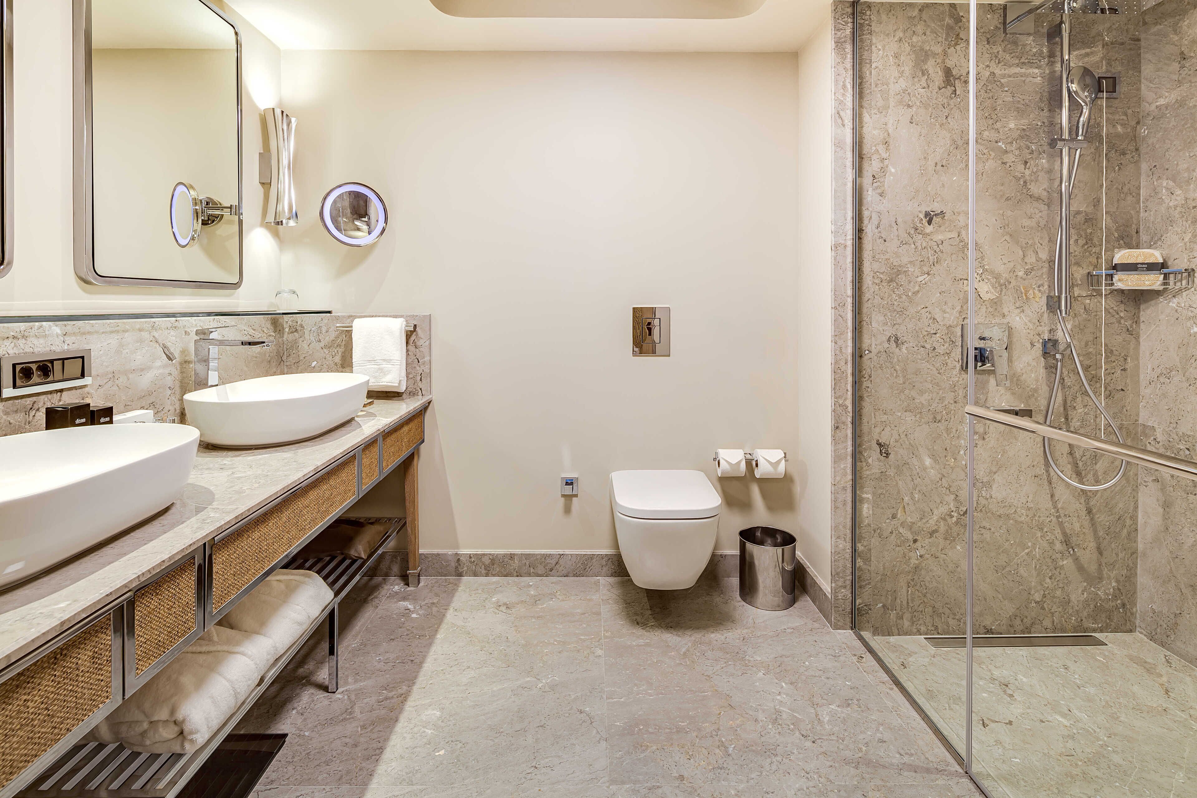 A modern bathroom with a large sink, mirror, and shower.