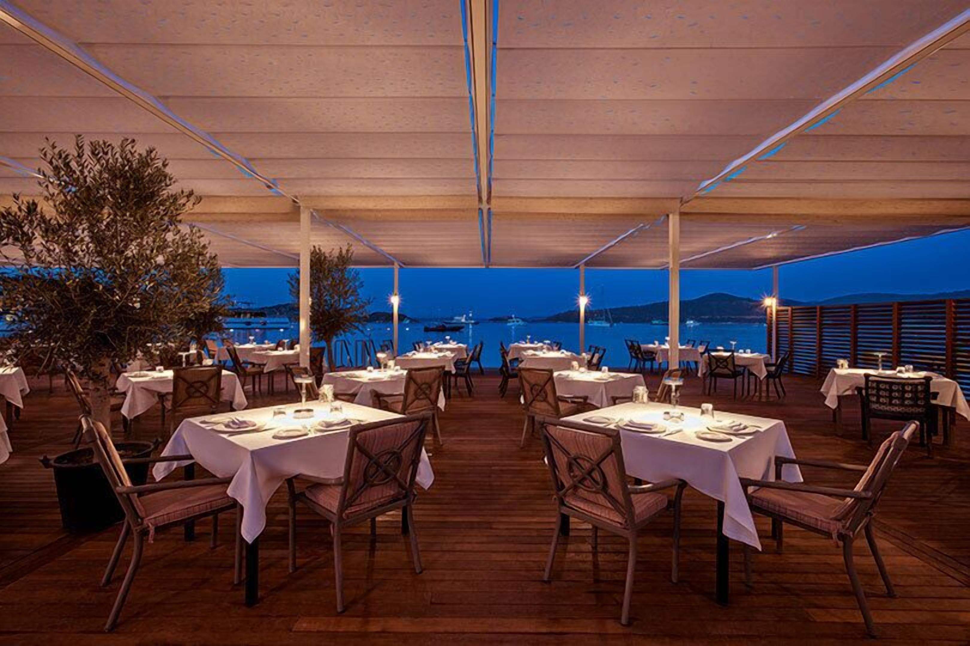An outdoor dining area with tables and chairs, overlooking a scenic view.
