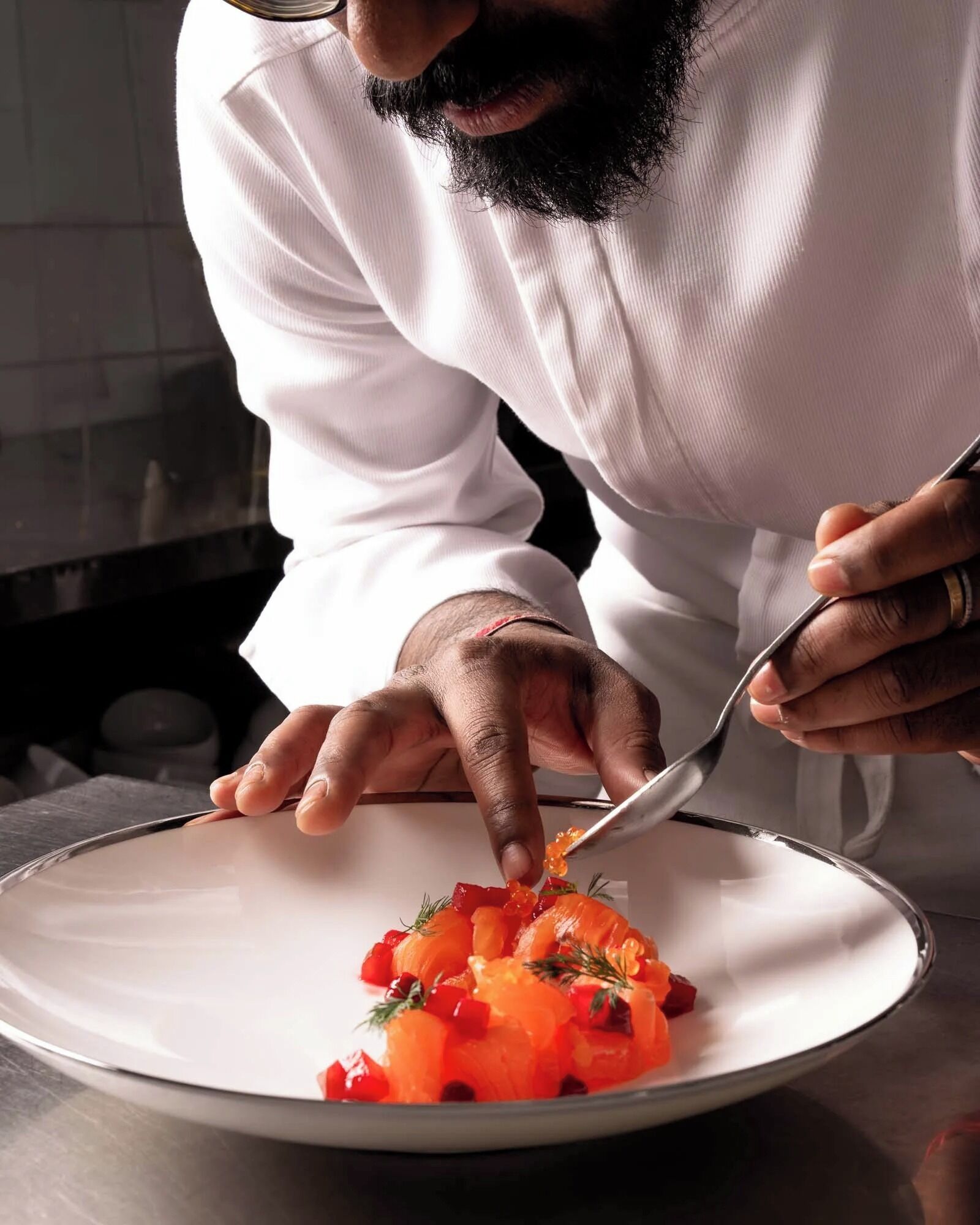 A person in a white shirt serving food on a white plate.
